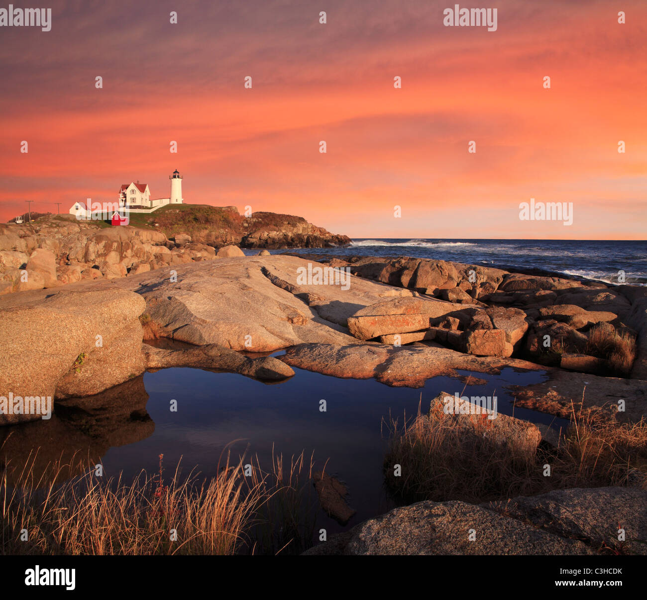 Un classico del faro, Sunset Skies al Nubble luce, una nuova pastorale Inghilterra Seascape, Cape Neddick, Maine, Stati Uniti d'America Foto Stock