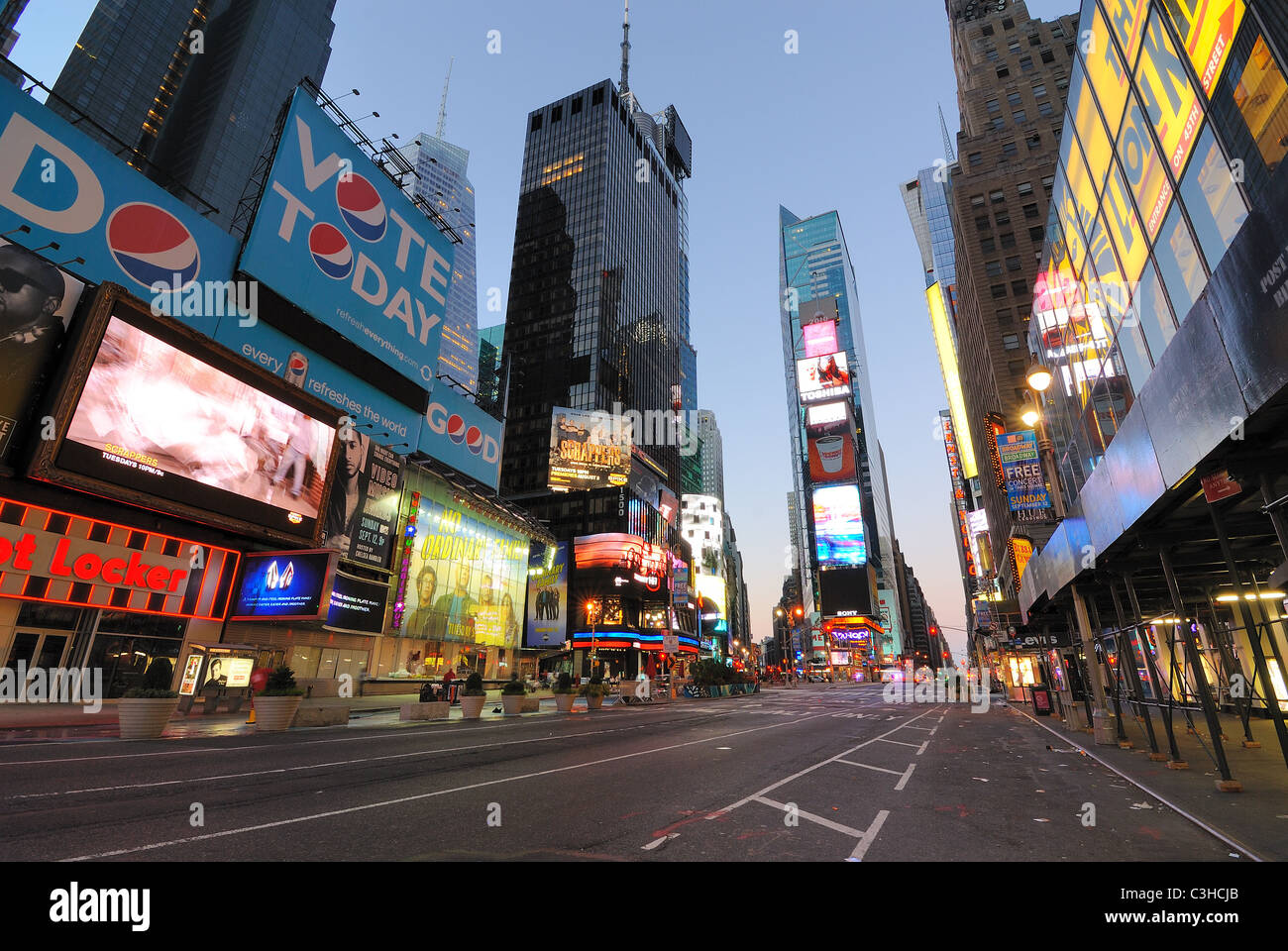 Vetrine e annunci pubblicitari in un insolitamente deserta Times Square a New York City all'alba. Foto Stock