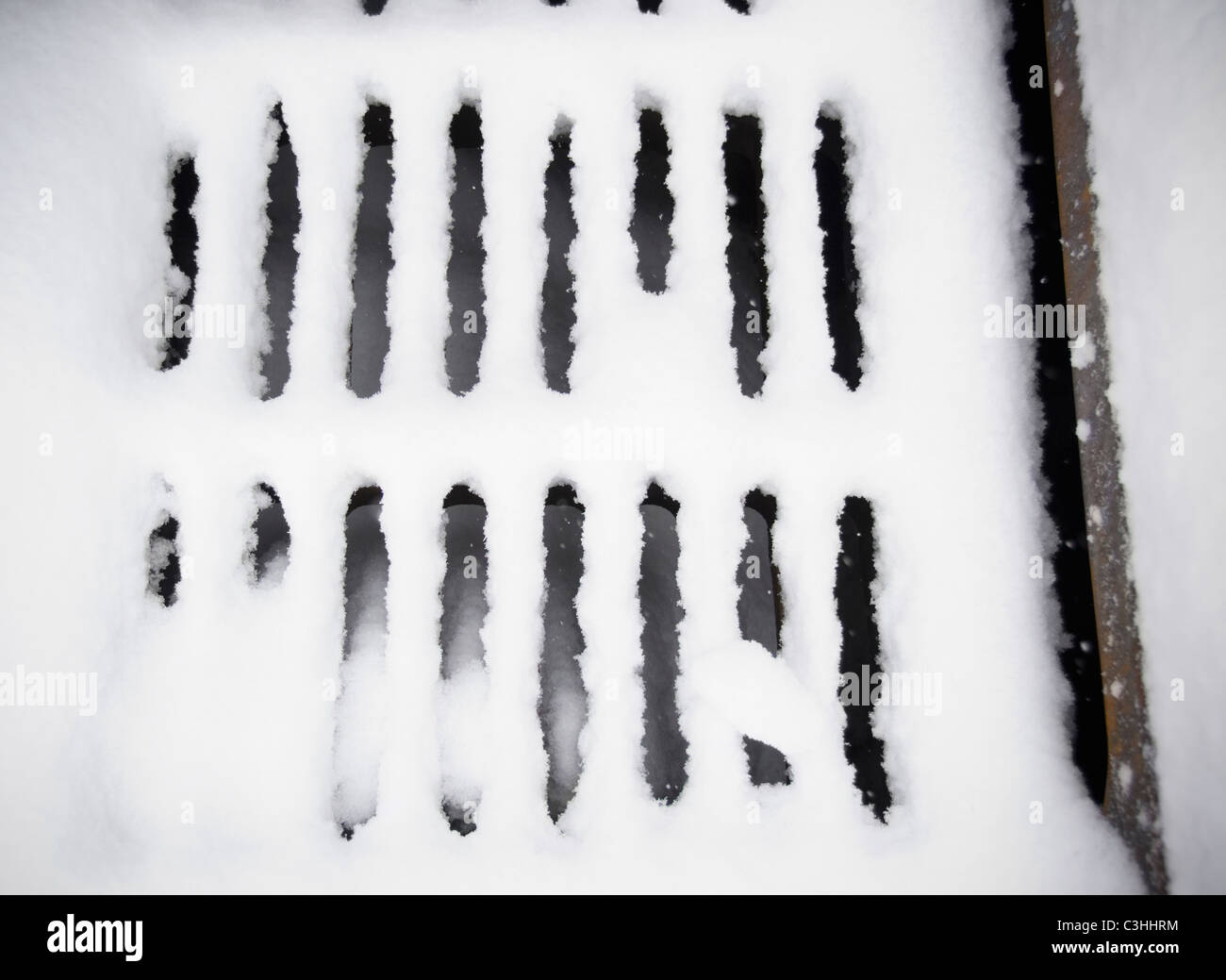 Coperta di neve di fognature griglia Foto Stock