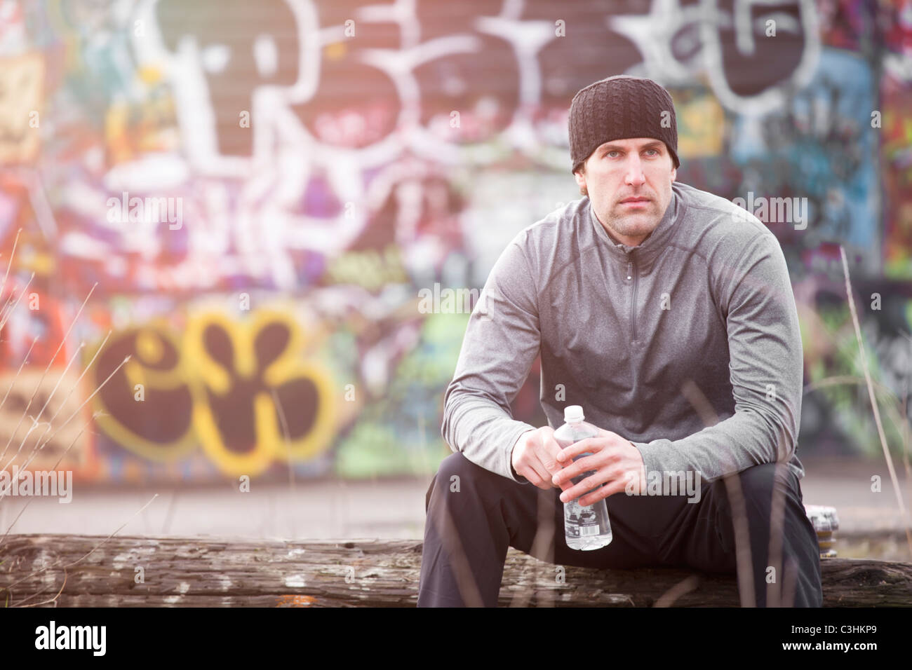 Uomo in allenamento usura nella parte anteriore del muro di graffiti Foto Stock