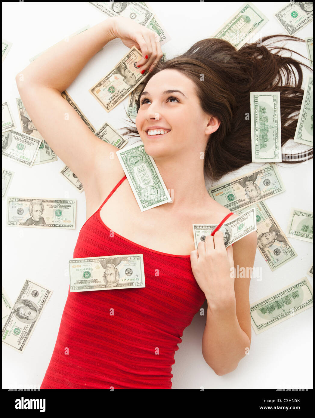 Giovane donna giacente in denaro Foto Stock