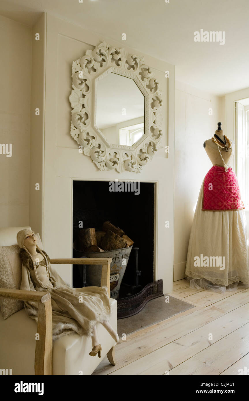 Ornato specchio sopra caminetto in soggiorno con il manichino e mannequin doll su poltrona Foto Stock