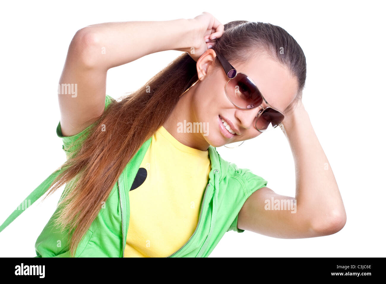 La donna in una maglietta gialla e giacca verde in posa su uno sfondo bianco Foto Stock