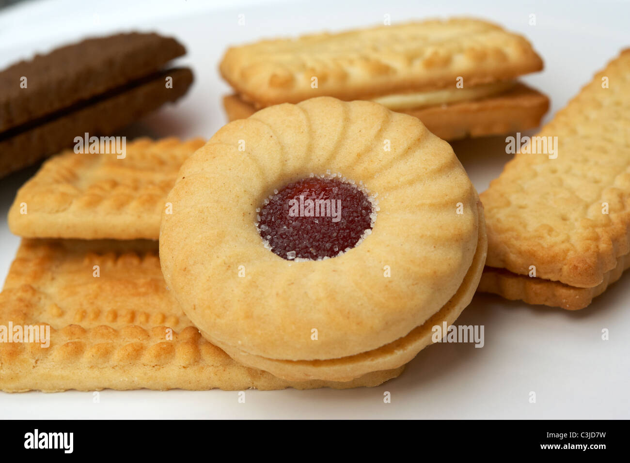 Un assortimento di biscotti inglesi su una piastra comprendente un jammie dodger Foto Stock