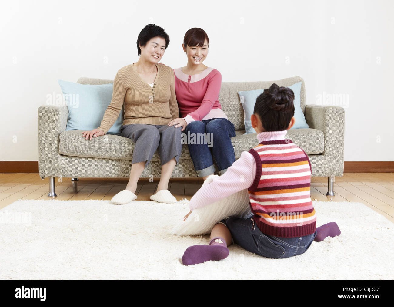 Tre generazioni di una famiglia rilassante in camera Foto Stock