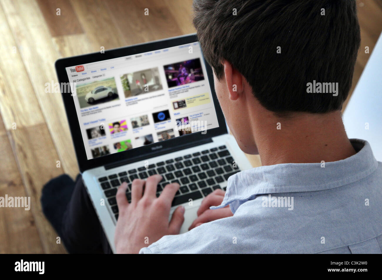 Giovane maschio con un computer portatile su You Tube pagina. Foto Stock