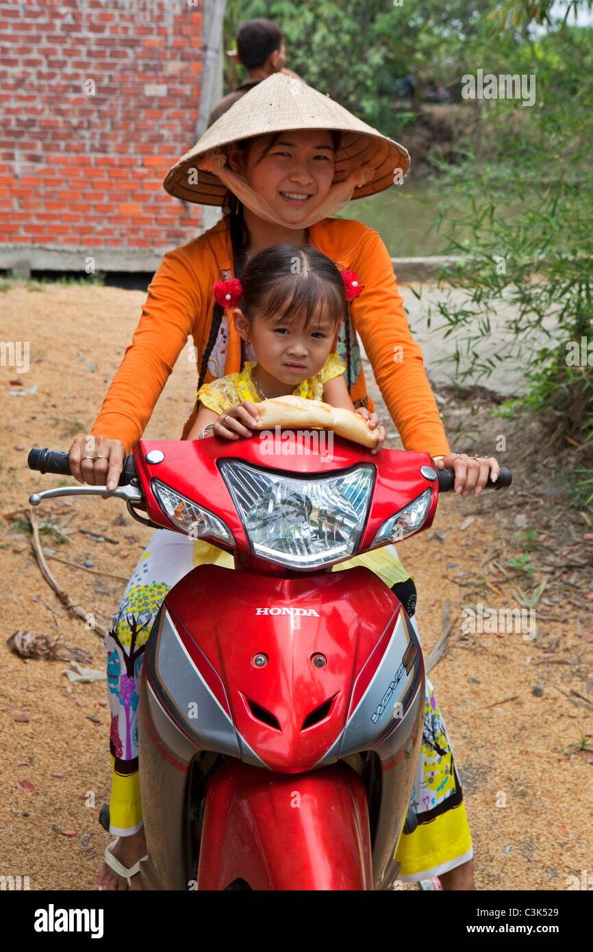 Madre e figlia sul moto del Fiume Mekong Delta, Vietnam Foto Stock