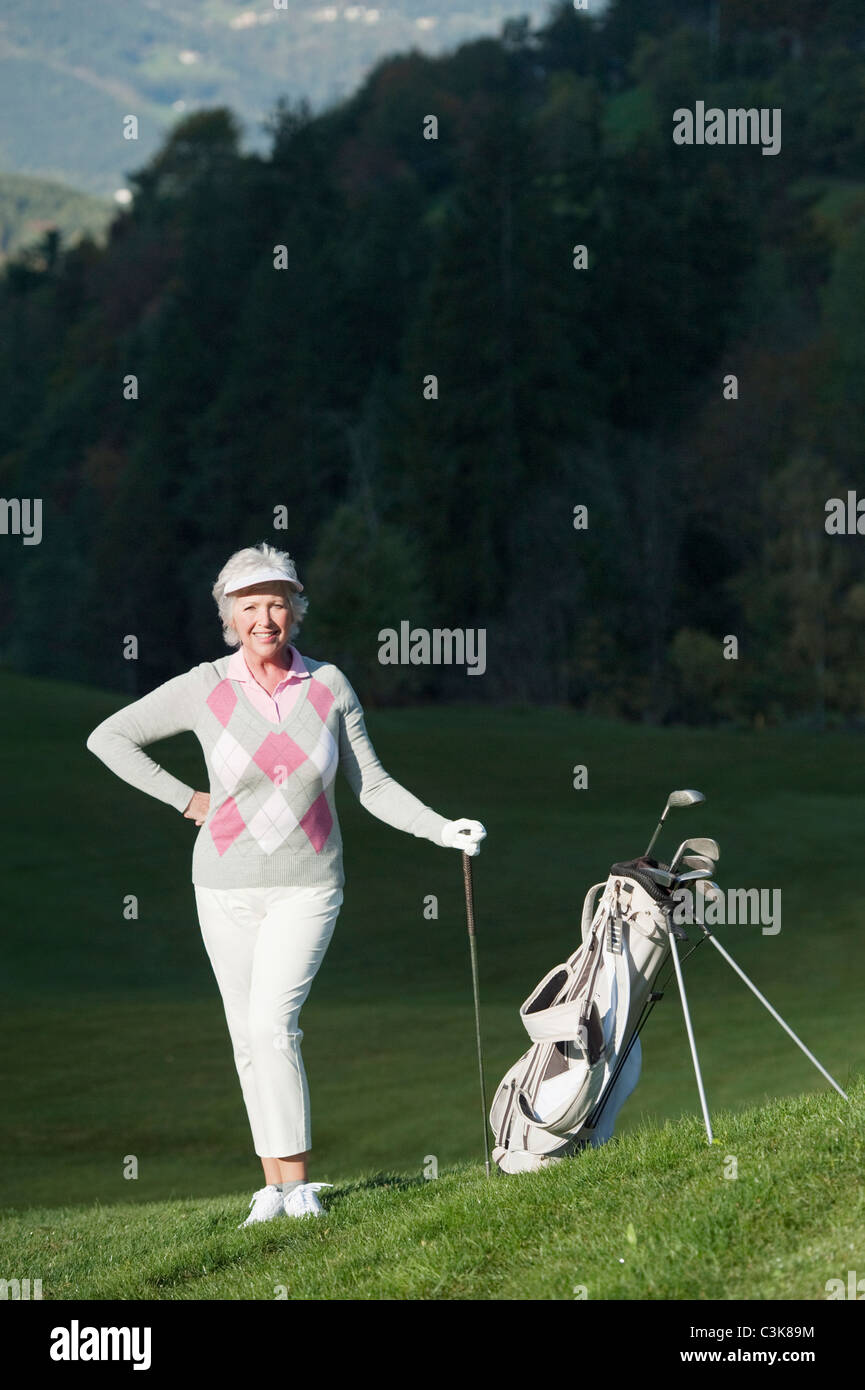 L'Italia, Castelrotto e donna matura con borsa da golf sul campo da golf Foto Stock