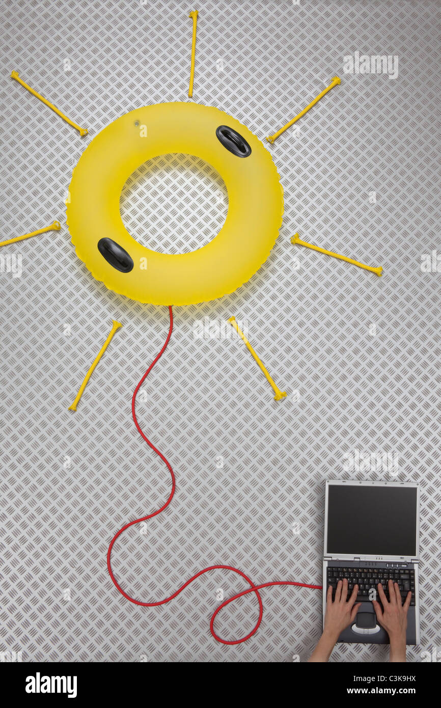 Donna che utilizza un laptop collegato con galleggiante di formatura forma di Sun Foto Stock