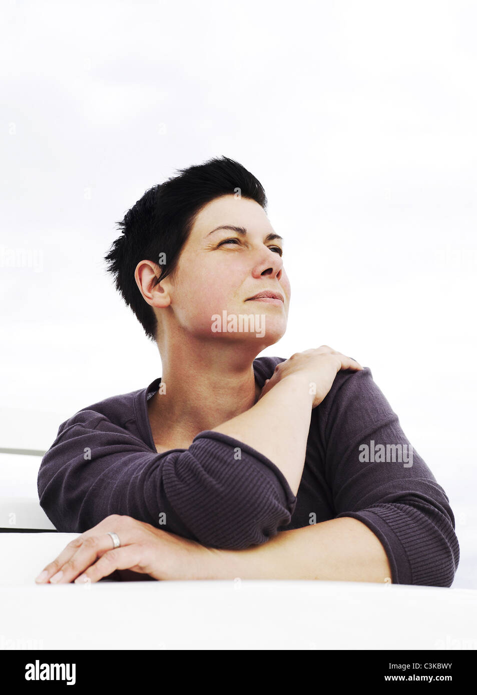 Donna seduta e guardando in alto Foto Stock