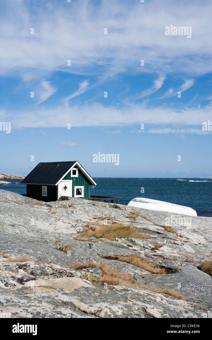 Un verde cottage e una barca su una scogliera, Bohuslan, Svezia. Foto Stock