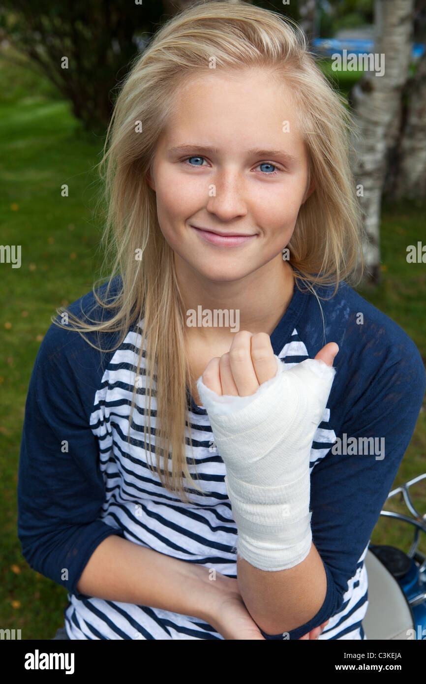 Ragazza adolescente con bendaggio a portata di mano, sorridente, ritratto Foto Stock