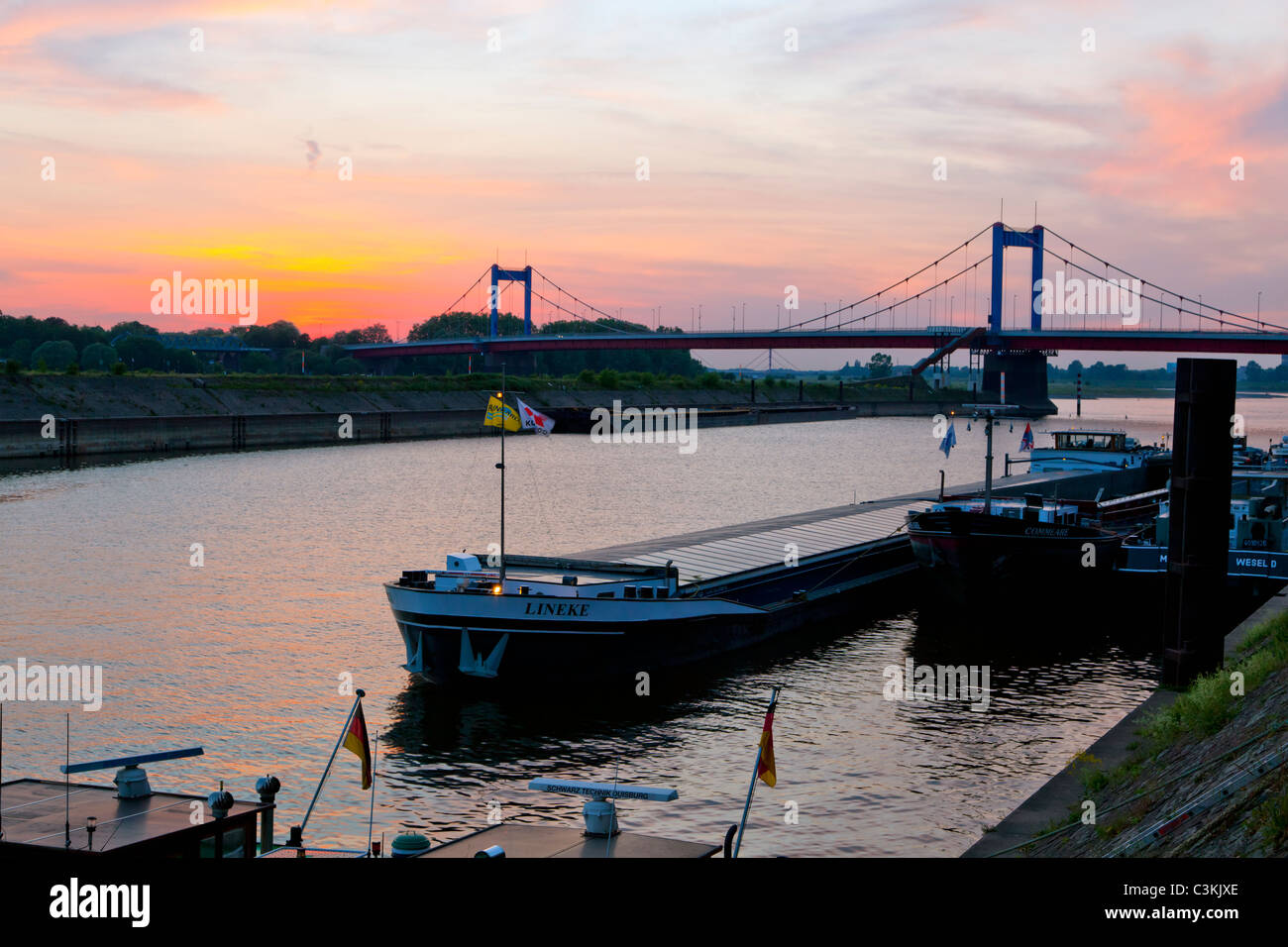 Navi merci presso il porto di Duisburg-Ruhrort al tramonto Foto Stock