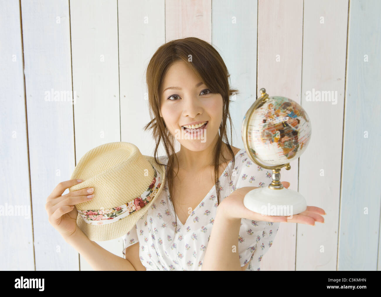 Giovane donna holding globe e hat Foto Stock