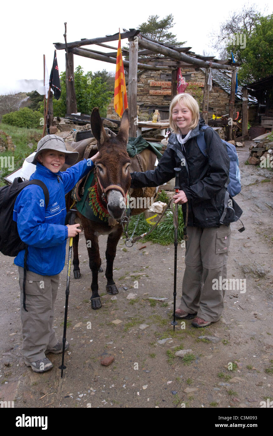 Un asino e turisti sul percorso del pellegrinaggio in Manjarin, Camino de Santiago, Spagna settentrionale Foto Stock