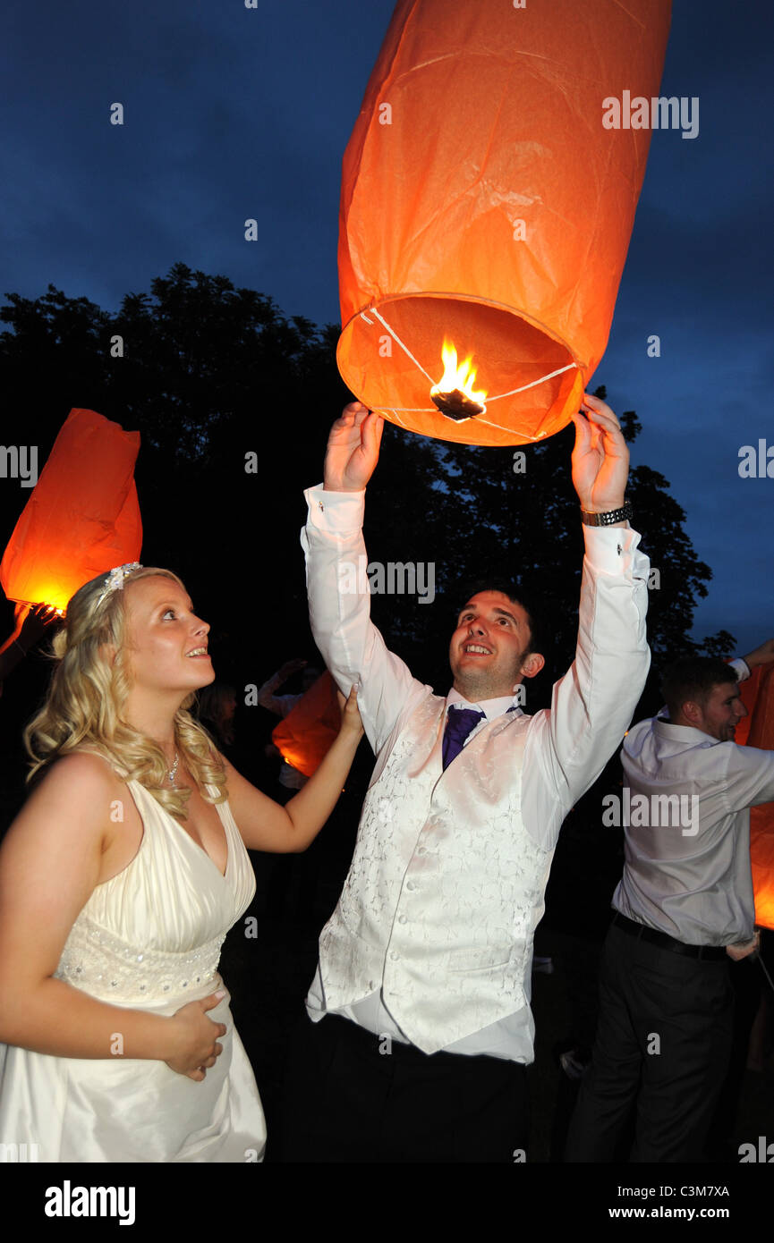 Gli sposi lanciare una lanterna cinese al party di nozze reception Foto Stock
