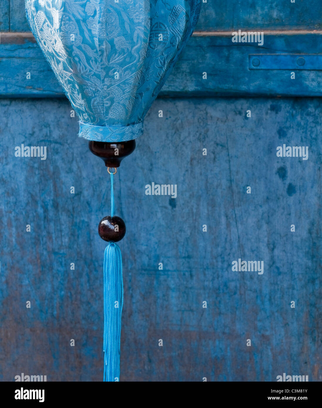 Seta blu lanterna contro blu porta di legno, Hoi An, Viet Nam Foto Stock