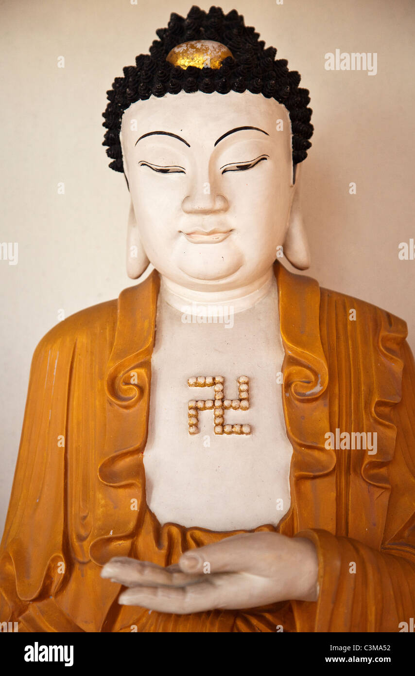 Statua di un Buddha con la svastica segno Foto Stock