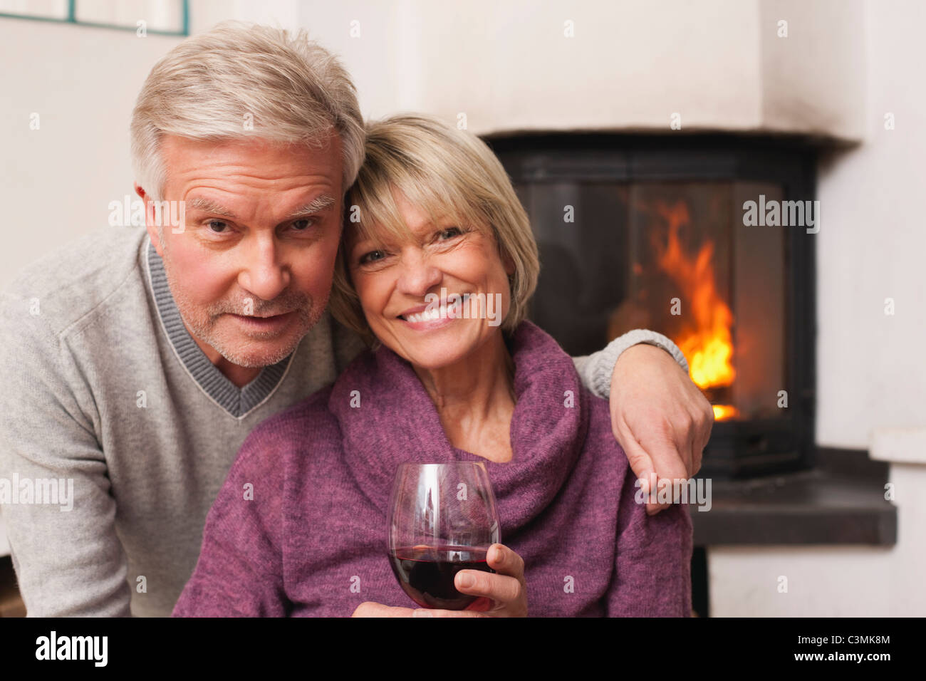 Germania, Kratzeburg, coppia Senior con bicchiere di vino, sorridente, ritratto Foto Stock