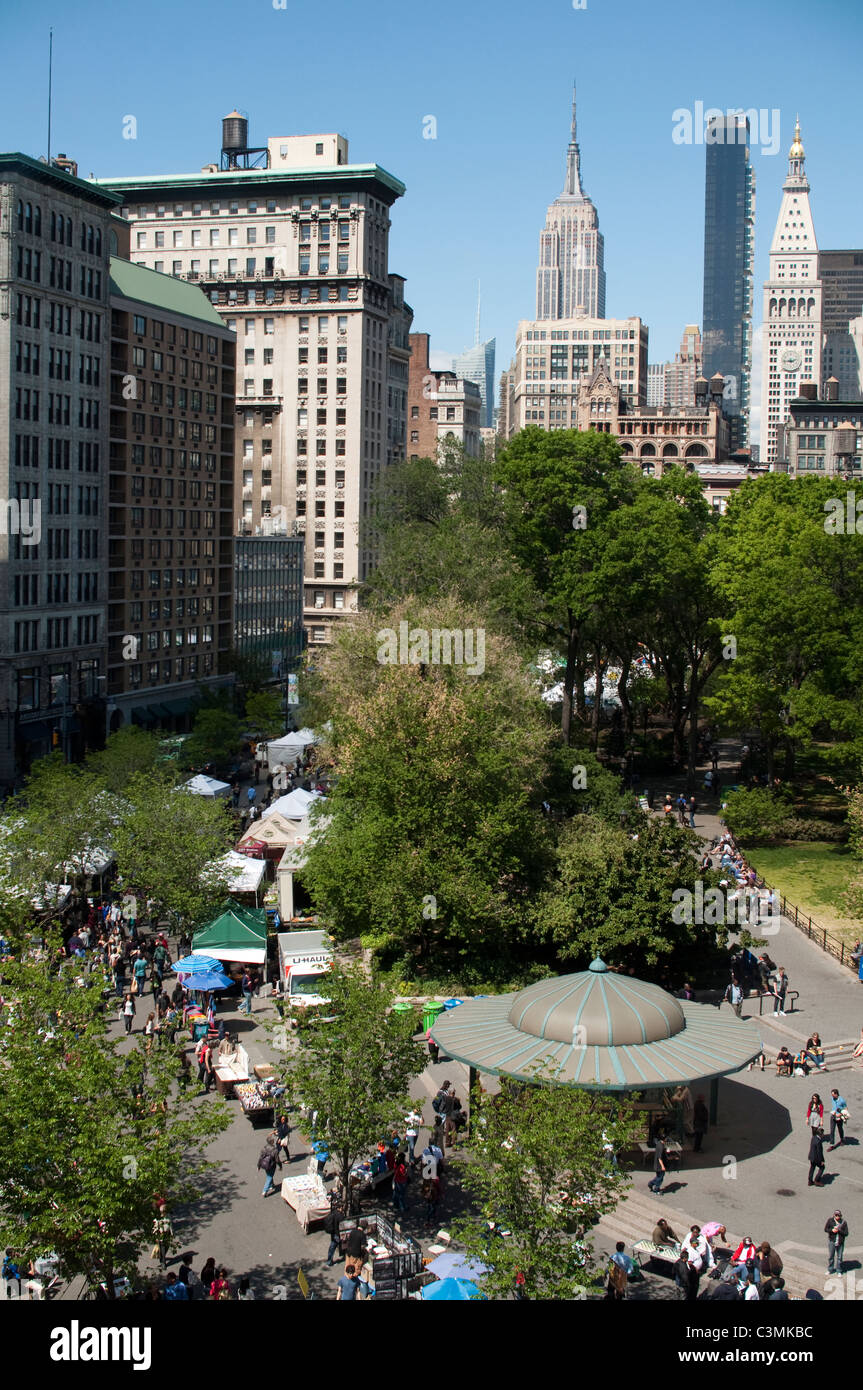 Guardando a Nord di Union Square Park su un giorno Greenmarket. L'Empire State Building domina lo skyline di distanza. Foto Stock