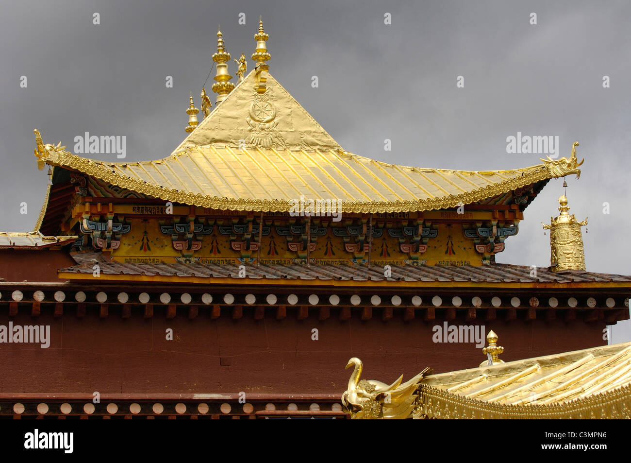 Ornamenti dorati in corrispondenza degli angoli del tetto del monastero Songzhanling. Zhongdian, Cina Foto Stock