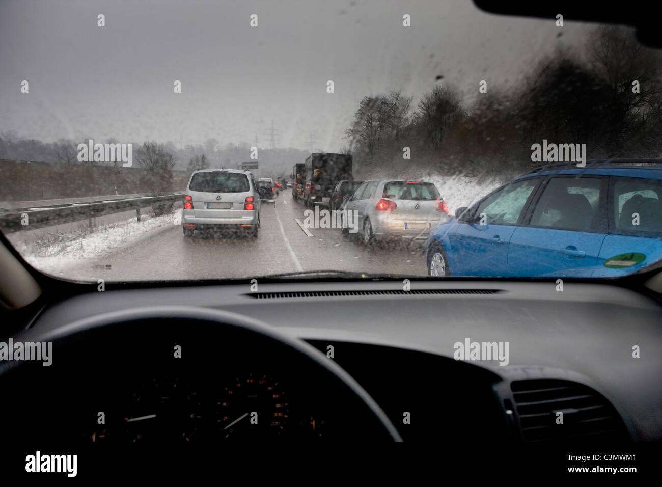 Inceppamento di traffico su una strada principale nella Germania meridionale, sporco winterly meteo Foto Stock