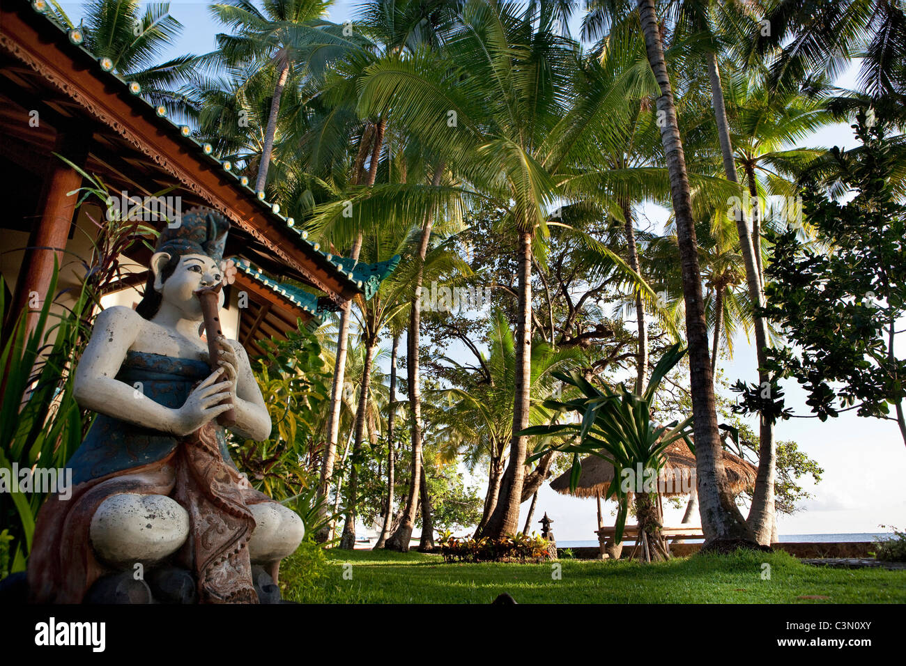 Indonesia, isola di Bali, vicino al villaggio di Tejakula, Gaia Oasis Resort. Statua di fronte al bungalow. Foto Stock