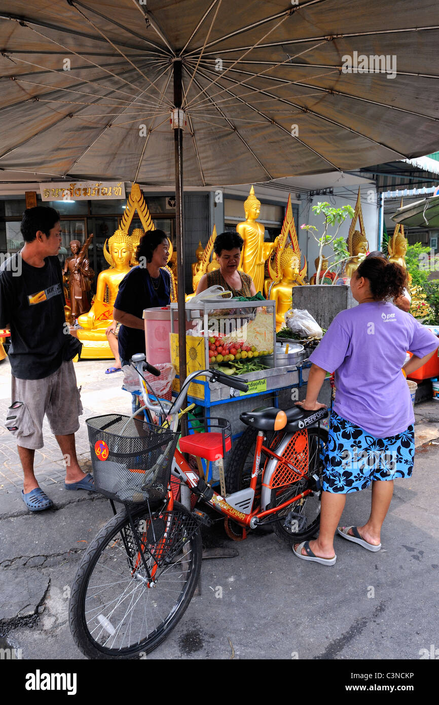 Cibo di strada di vendita del fornitore somtam, il popolare speziata insalata di papaia. Strade di Bangkok, Tailandia. Foto Stock