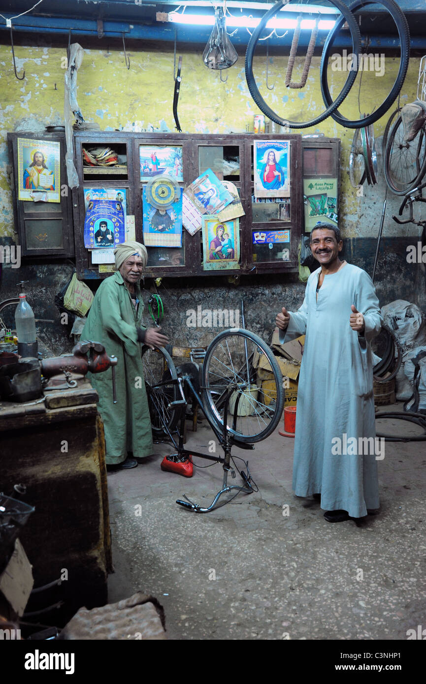 Africa Medio Oriente egiziano Egitto Luxor El Souk vicolo Mercato il cibo e lo shopping - due uomini in un negozio di riparazione di biciclette Foto Stock