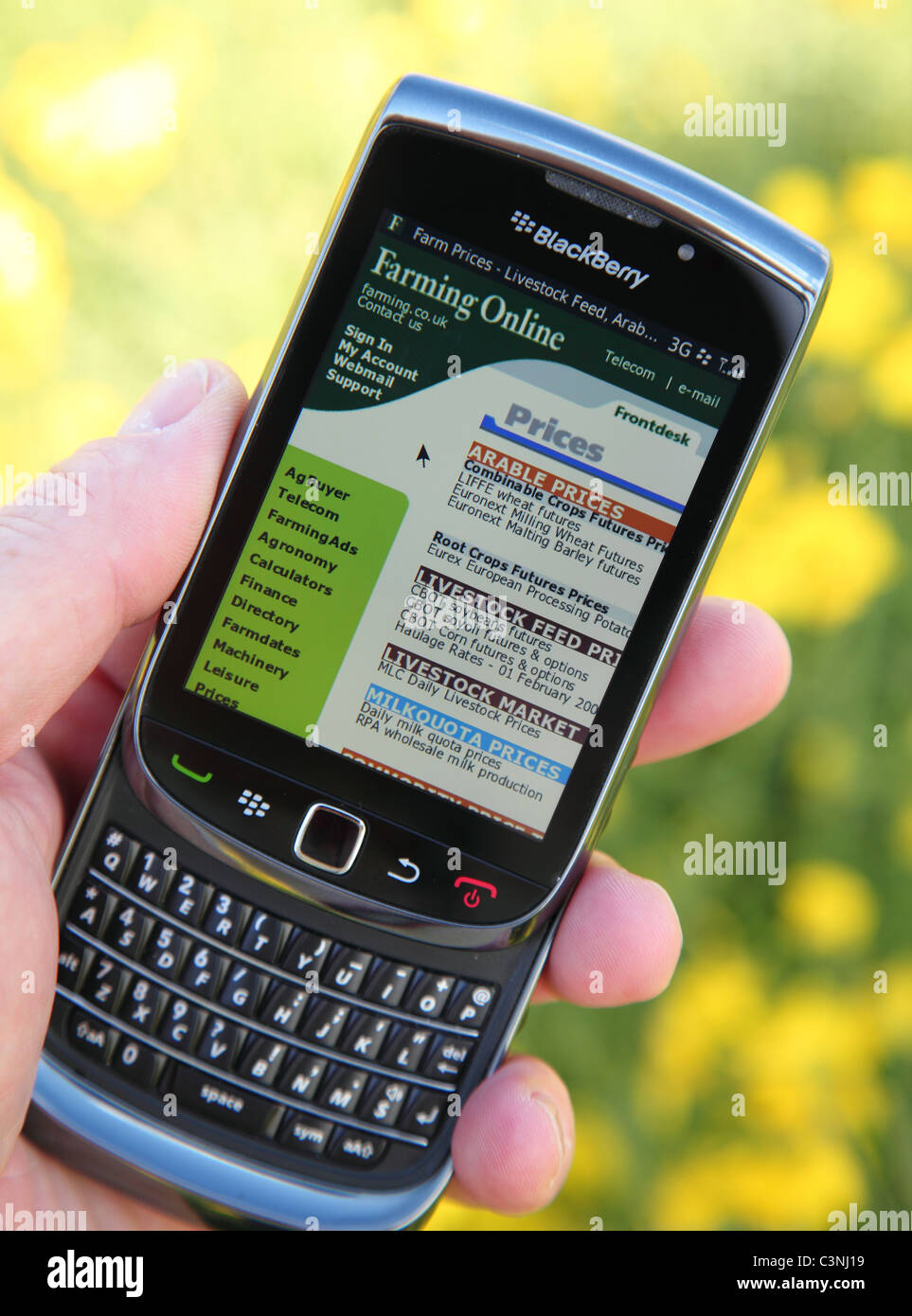 Un agricoltore che utilizza Blackberry per controllare la coltivazione di seminativi prezzi su una fattoria in U.K. Foto Stock