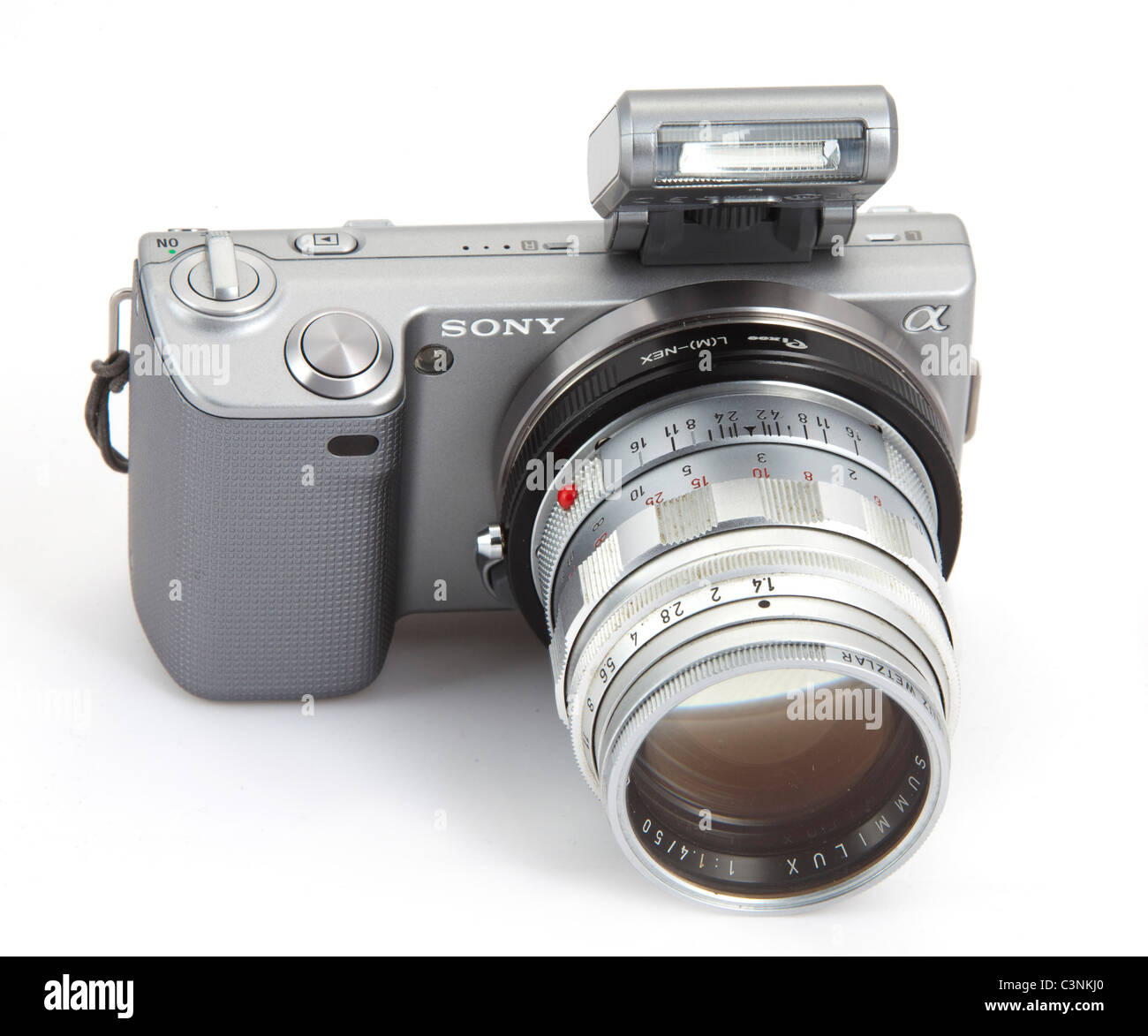 Sony Alpha NEX5 fotocamera digitale con flash esterno e adattatore con Summilux Leica 50mm f 1.4 M lente 117928 Leica Foto Stock