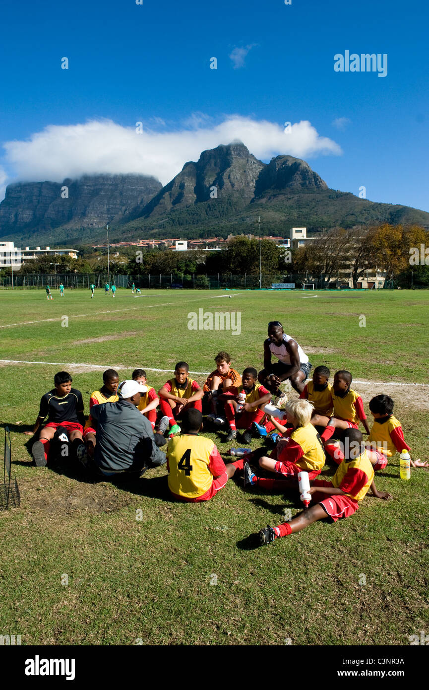 Coach intstructing U13 giocatori di calcio durante il break a metà tempo Città del Capo Sud Africa Foto Stock