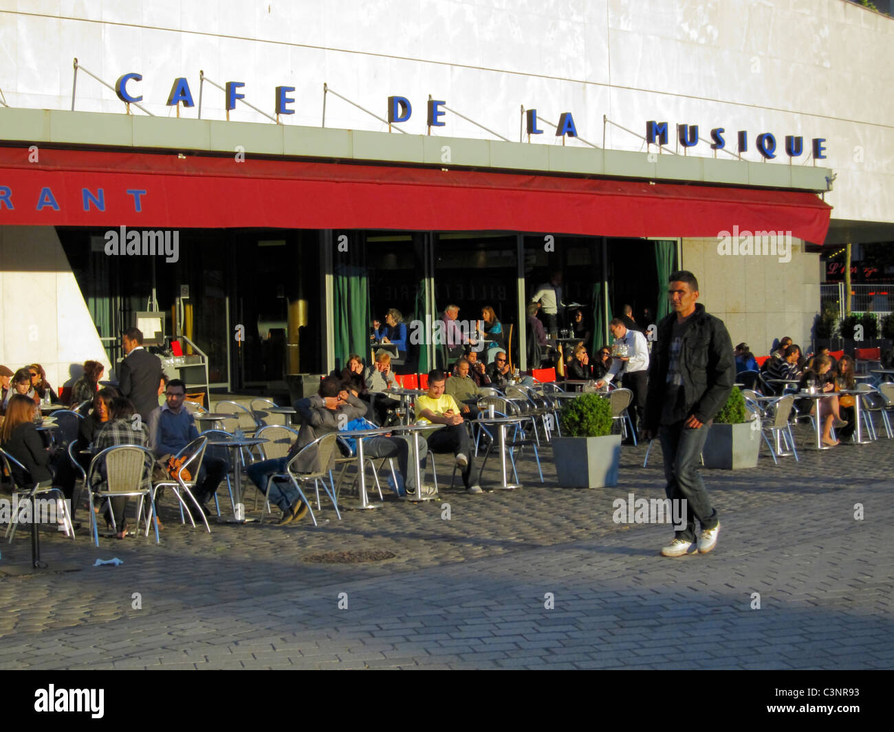 Parigi, Cafe, Francia, la Villette Park, Crowd Sharing Drinks, Terrazza esterna in Piazza della città, "Café de la Musique", scena di strada parigina, marciapiede, vacanza, scena di caffè francese all'esterno città di SC-ience e industria parigi Foto Stock