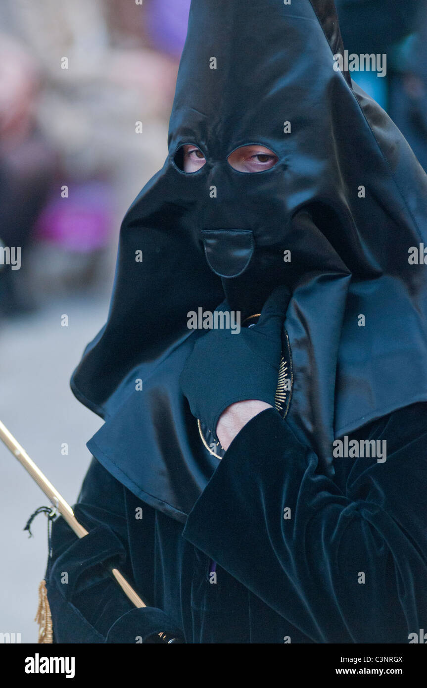 Con cappuccio nero penitente alla sera Venerdì Santo Processione attraverso le vie della città di Murcia, sud orientale della Spagna Foto Stock