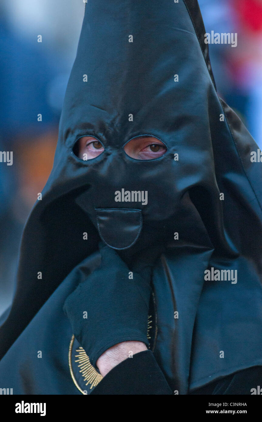 Con cappuccio nero penitente alla sera Venerdì Santo Processione attraverso le vie della città di Murcia, sud orientale della Spagna Foto Stock