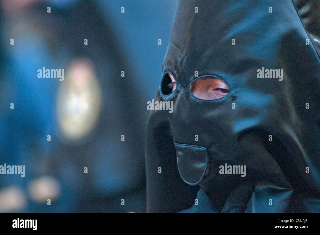 Con cappuccio nero penitente alla sera Venerdì Santo Processione attraverso le vie della città di Murcia, sud orientale della Spagna Foto Stock