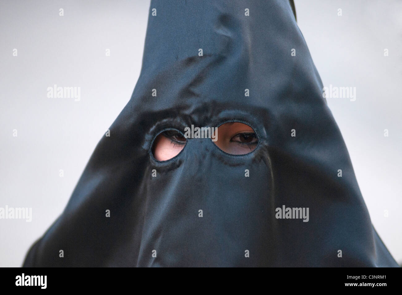 Con cappuccio nero penitente alla sera Venerdì Santo Processione attraverso le vie della città di Murcia, sud orientale della Spagna Foto Stock