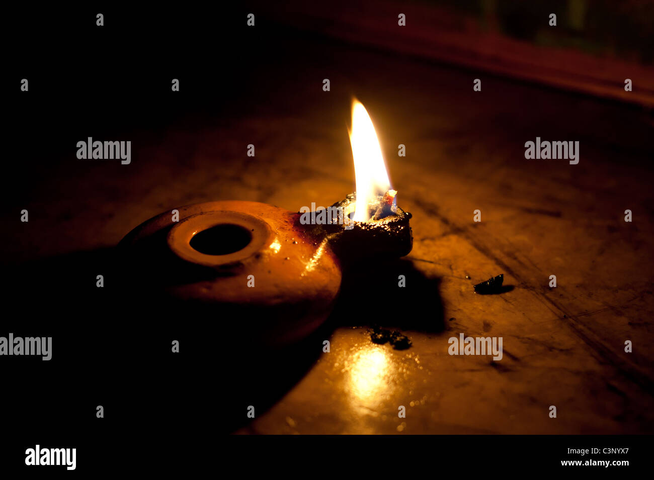 Una ceramica di olio d'oliva lampada consente di proiettare la luce in una stanza buia. Foto Stock