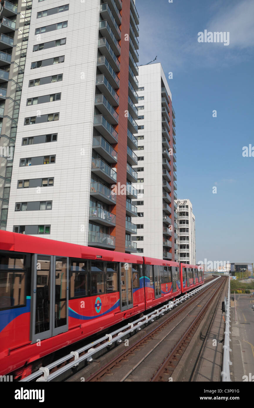 Un Docklands Light Railway (DLR) treno passa nuovi blocchi a torre vicino a est dell India, Stazione di East London, Regno Unito. Foto Stock