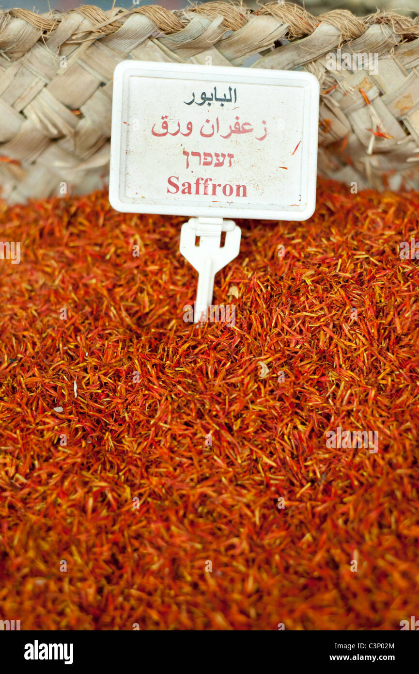 Un mucchio di zafferano essiccato etichettato in arabo, ebraico e le lingue inglese, riempie un bin in una spezie e prodotti asciutti store a Nazareth, Israele. Foto Stock