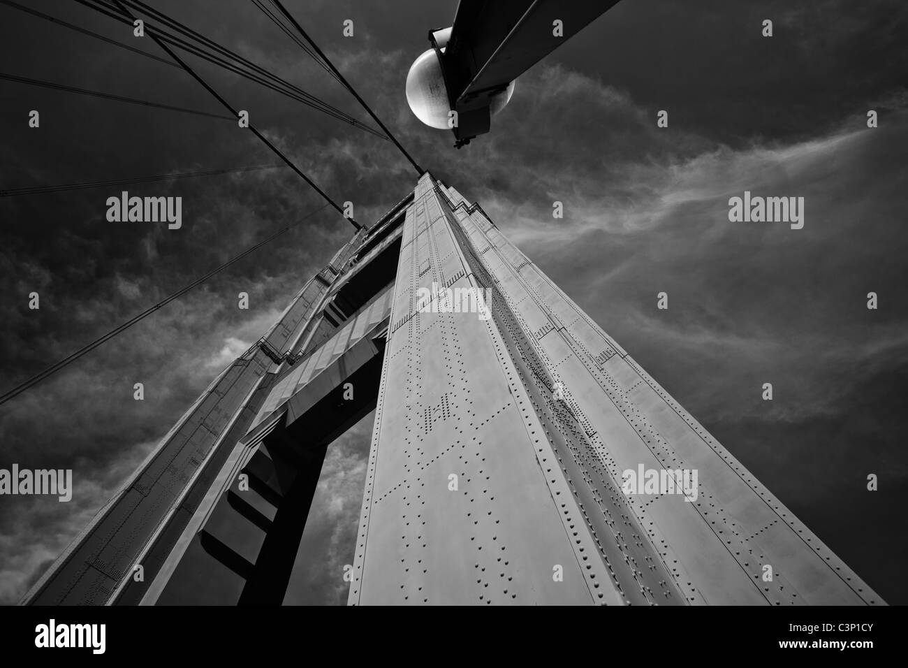 Un'immagine ad angolo basso di una torre di ponte, che mostra i rivetti e la costruzione della torre, con un apparecchio di illuminazione nella parte superiore. Foto Stock