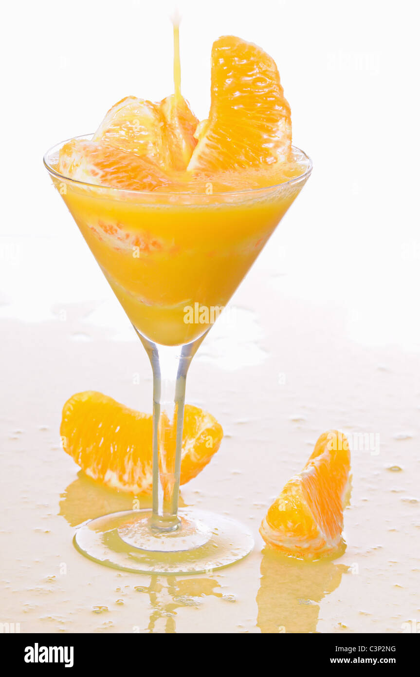 Il succo di arancia in una wineglass isolati su sfondo bianco Foto Stock