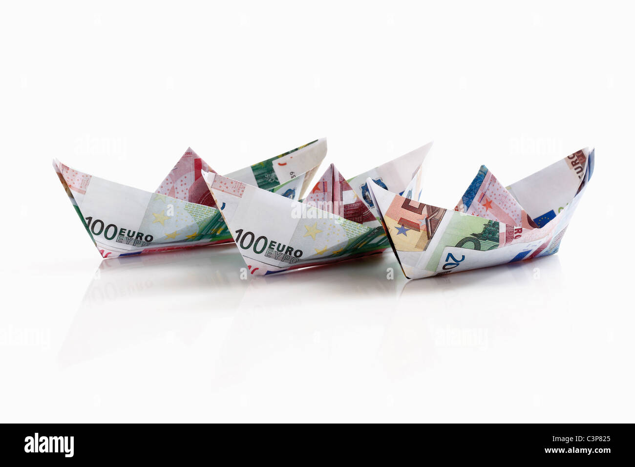Carta Origami di barche di banconote su sfondo bianco Foto Stock
