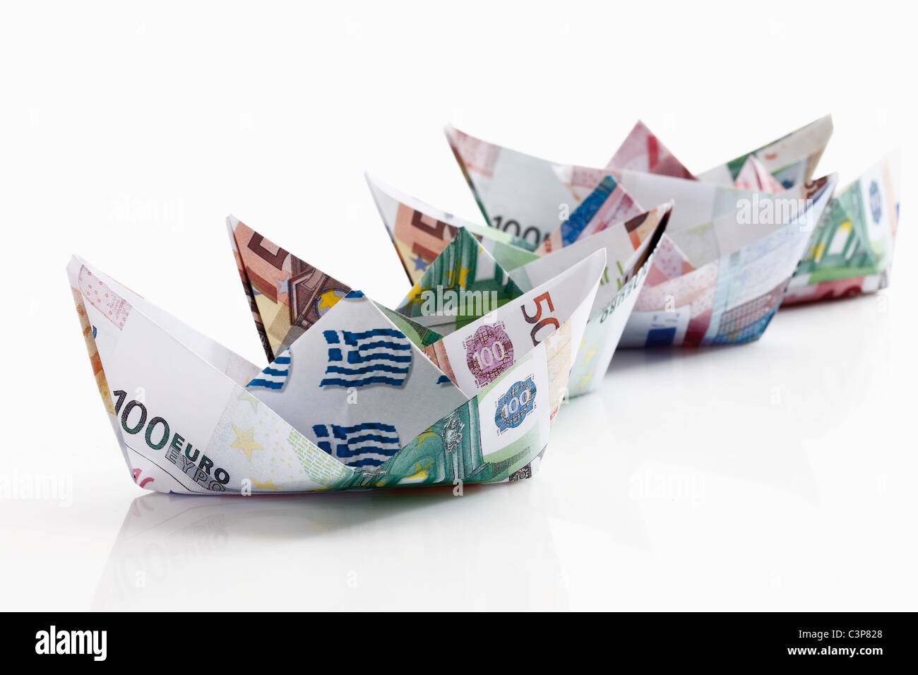 Carta Origami di barche di banconote su sfondo bianco Foto Stock