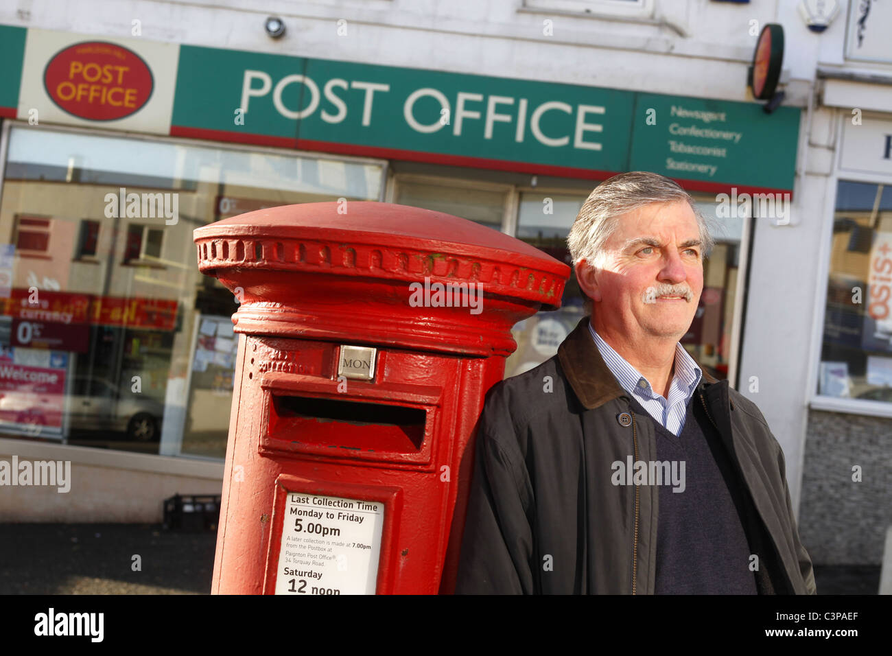 Postmaster al di fuori di un Devon Post Office. Foto Stock