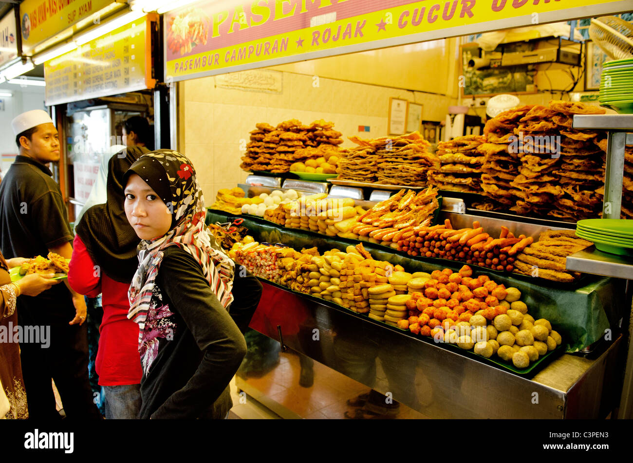 Musulmana velata ragazza a snack stand in penang malaysia Foto Stock