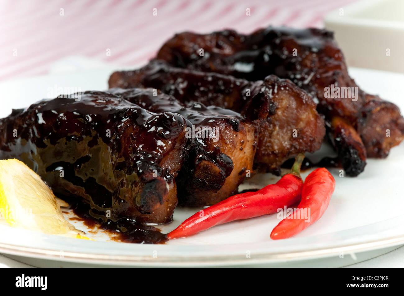 Molto appiccicoso costolette su di un piatto con ingredienti. Foto Stock
