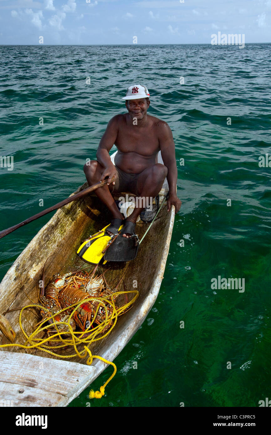 Un pescatore di aragoste si mette in mostra la sua cattura in Belize. Foto Stock