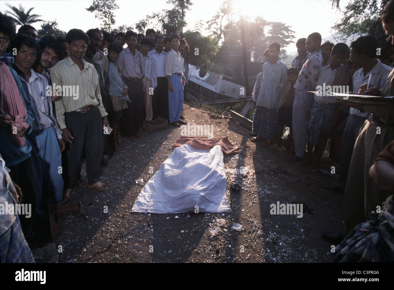 Arrabbiato abitanti raccogliere circa il corpo morto di un pedone locale ucciso da un bus di controllo nello Stato di Orissa India orientale. Foto Stock