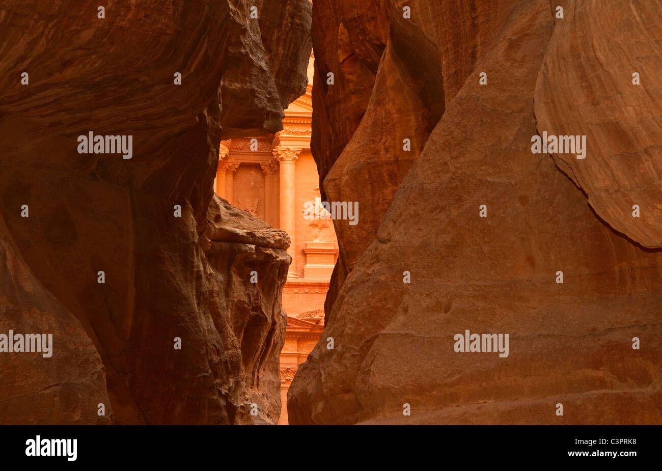 Una vista del tempio o tesoro in Petra Giordania attraverso la fessura di arenaria canyon. Foto Stock